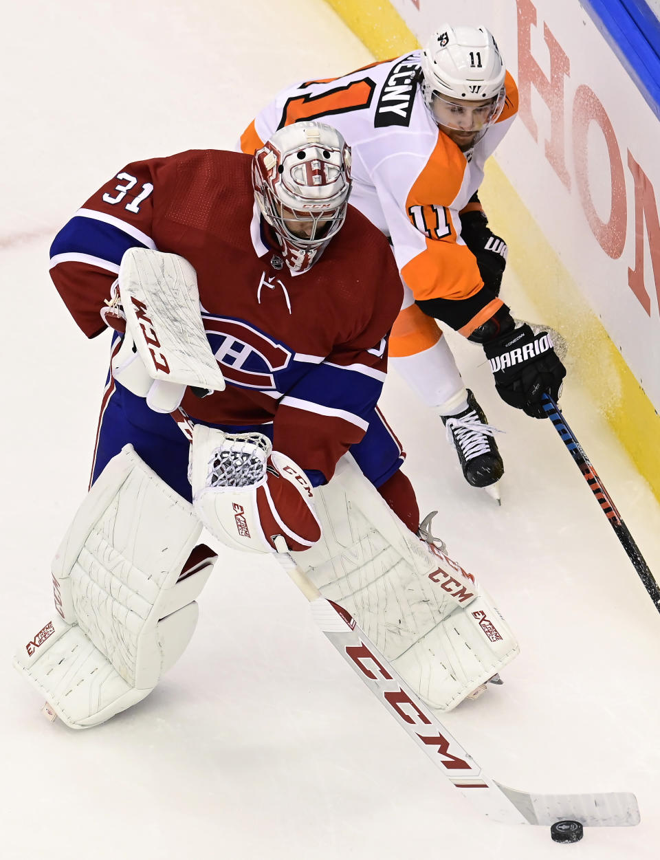 Philadelphia Flyers right wing Travis Konecny (11) looks for an opportunity as Montreal Canadiens goaltender Carey Price (31) clears the puck from behind the net during the second period of Game 3 of an NHL hockey playoff first-round series Sunday, Aug. 16, 2020, in Toronto. (Frank Gunn/The Canadian Press via AP)