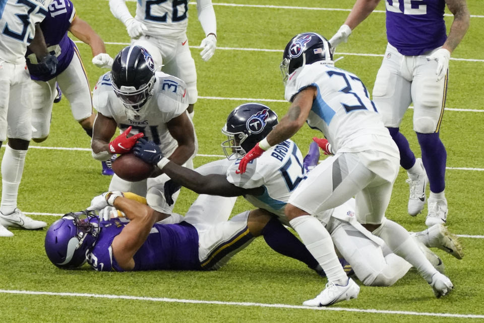 Tennessee Titans free safety Kevin Byard (31), inside linebacker Jayon Brown (55) and safety Amani Hooker (37) strip the ball from Minnesota Vikings wide receiver Adam Thielen during the second half of an NFL football game, Sunday, Sept. 27, 2020, in Minneapolis. (AP Photo/Jim Mone)