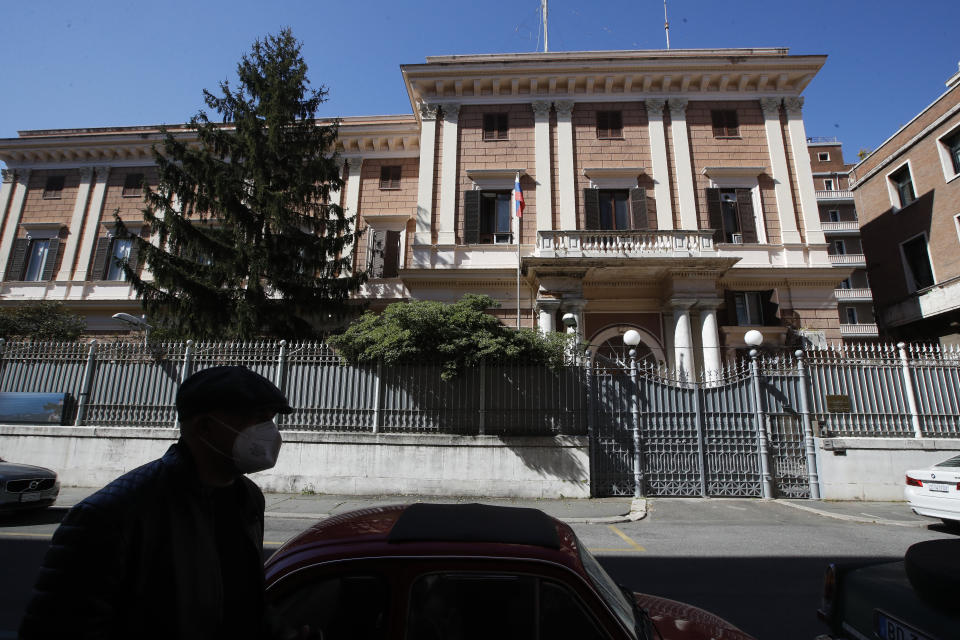 A man walks past the Russian Embassy in Rome, Wednesday, March 31, 2021. Italy has ordered two Russian Embassy officials expelled and arrested an Italian Navy captain on spying charges after police caught the Italian allegedly giving classified documents to one of the Russians in exchange for money. (AP Photo/Alessandra Tarantino)