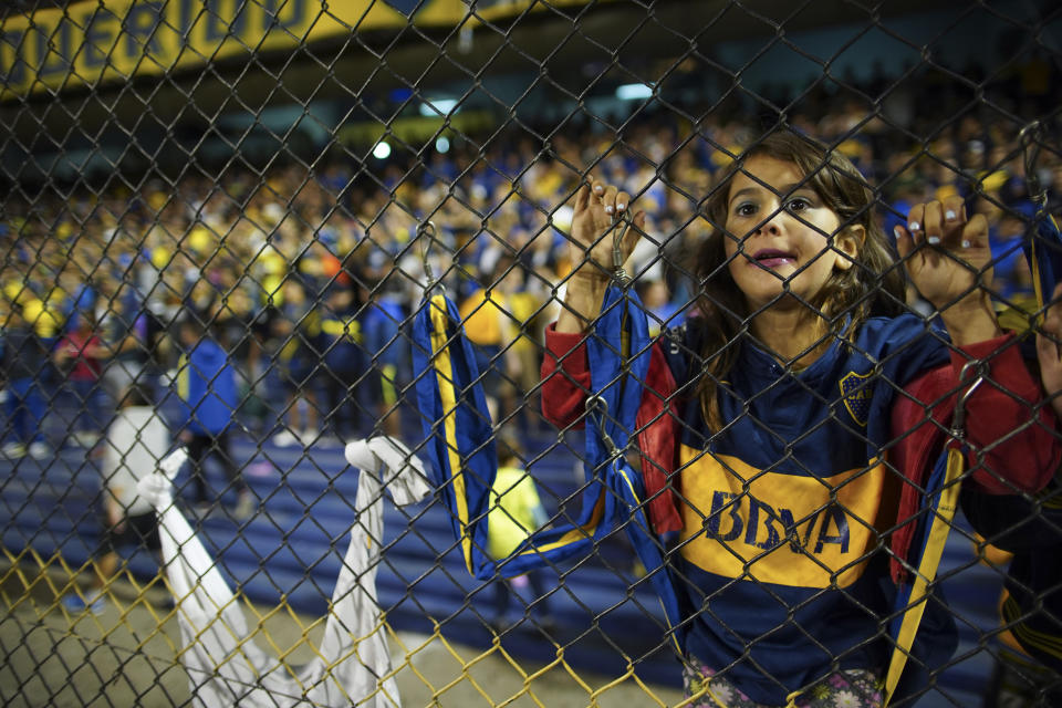 A young Boca Juniors' fan watches the Superliga women's tournament soccer match between Boca Juniors and Lanus in Buenos Aires, Argentina, Saturday, March 9, 2019. The women competed in one of Argentina's most famous stadiums on Saturday, a milestone for the female players who are fighting for the same rights as male soccer players in the country's most popular sport. (AP Photo/Natacha Pisarenko)