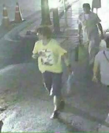A man wearing a yellow T-shirt and carrying a backpack is seen walking near the Erawan shrine, where a bomb blast killed 22 people on Monday, in Bangkok, Thailand in this handout still image taken from closed-circuit television (CCTV) footage, released by the Thai Police on August 18, 2015. Thai authorities said on Tuesday they were looking for this suspect seen on CCTV footage near the popular shrine where the bomb blast killed 22 people, including nine foreigners from several Asian countries. REUTERS/Thai Police/Handout via Reuters ATTENTION EDITORS - THIS PICTURE WAS PROVIDED BY A THIRD PARTY. REUTERS IS UNABLE TO INDEPENDENTLY VERIFY THE AUTHENTICITY, CONTENT, LOCATION OR DATE OF THIS IMAGE. FOR EDITORIAL USE ONLY. NOT FOR SALE FOR MARKETING OR ADVERTISING CAMPAIGNS. THIS PICTURE IS DISTRIBUTED EXACTLY AS RECEIVED BY REUTERS, AS A SERVICE TO CLIENTS.