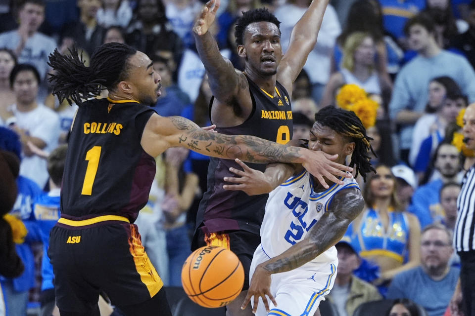 UCLA guard Dylan Andrews (2) is defended by Arizona State guard Frankie Collins (1) and center Shawn Phillips Jr. (9) during the first half of an NCAA college basketball game in Los Angeles, Saturday, March 9, 2024. (AP Photo/Jae C. Hong)