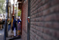 <p>A woman looks out from a door during a protest in Srinagar, against the recent killings in Kashmir region, Sept. 25, 2016. (Photo: Danish Ismail/Reuters)</p>