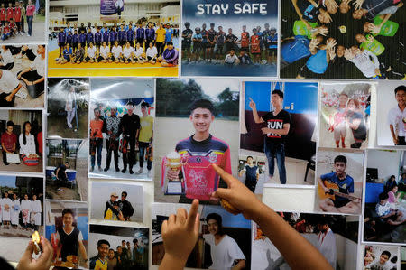 Children look at pictures of students before relatives and friends pray for the 12 schoolboys and their soccer coach trapped inside a flooded cave, at Mesai Grace Church in the northern province of Chiang Rai, Thailand, July 8, 2018. REUTERS/Soe Zeya Tun