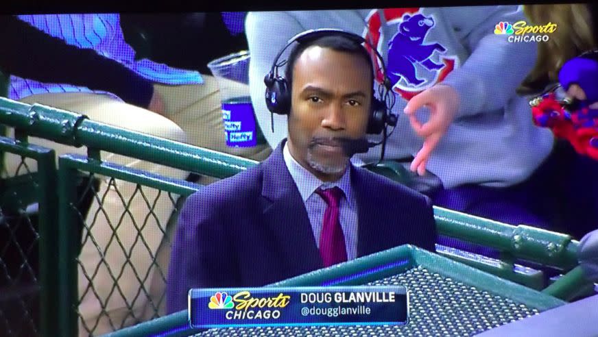 A fan in a gray sweatshirt flashes an alleged white power symbol behind NBC Sports Chicago reporter and former MLB player Doug Glanville. (Twitter/@Flipkin)