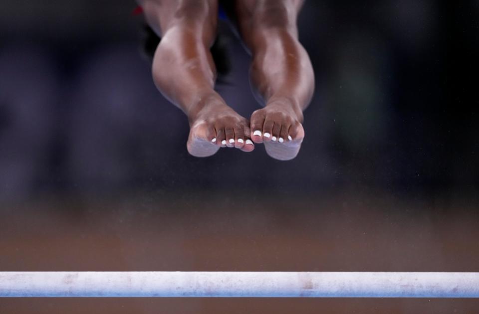 Simone Biles, of the United States, performs on the uneven bars during the women's artistic gymnastic qualifications at the 2020 Summer Olympics, Sunday, July 25, 2021, in Tokyo. 