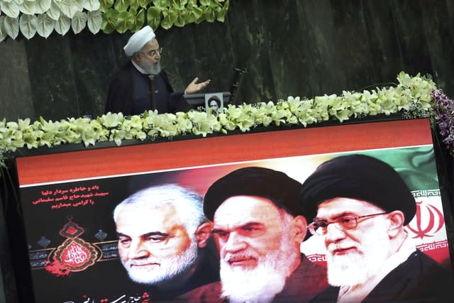 Iranian President Hassan Rouhani speaks during the inauguration of the new parliament, as a screen shows portraits of the Supreme Leader Ayatollah Ali Khamenei, right, late revolutionary founder Ayatollah Khomeini, centre, and Gen. Qassem Soleimani, who was killed in Iraq in a US drone attack (Vahid Salemi/AP)