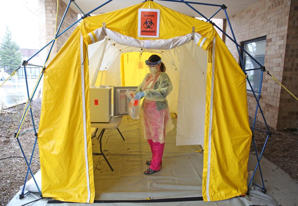 Sara Joachin, lead medical assistant for Ascension Wisconsin, works on placing collected refrigerated COVID-19 test samples prepared for pickup at a COVID-19 drive-thru testing location at Ascension St. Francis Medical Arts Pavilion in Milwaukee on April 27.