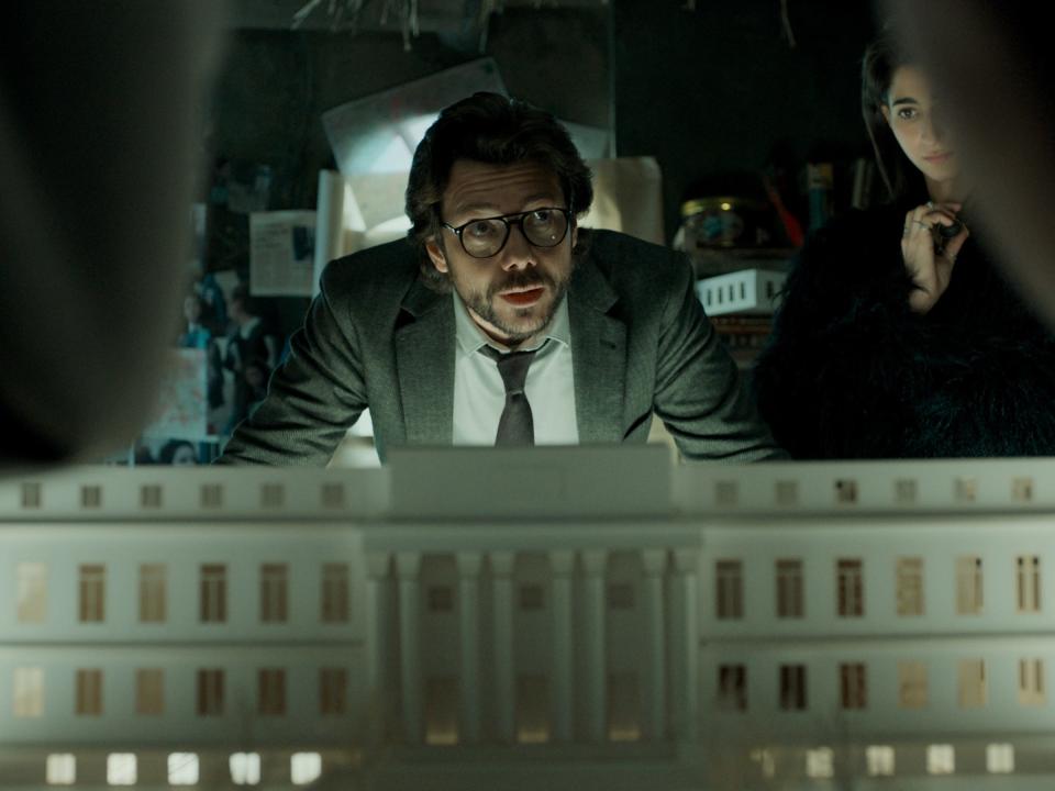 A still from "Money Heist," in which The Professor speaks in front of a model of a building.