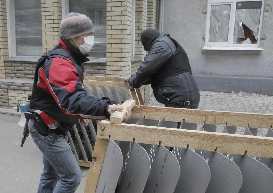 Armed pro-Russian activists occupy the police station in the eastern Ukraine town of Slovyansk on Saturday, April 12, 2014. Pro-Moscow protesters have seized a number of government buildings in the east over the past week, undermining the authority of the interim government in the capital, Kiev. (AP Photo/Efrem Lukatsky)