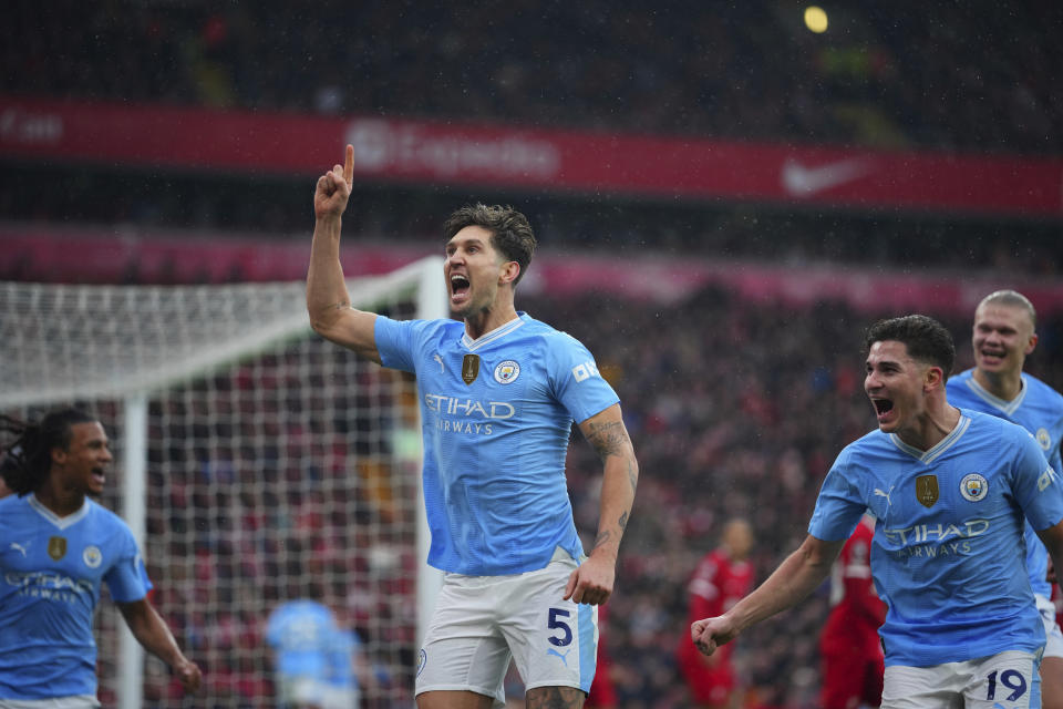 Manchester City's John Stones celebrates after scoring the opening goal of his team during the English Premier League soccer match between Liverpool and Manchester City, at Anfield stadium in Liverpool, England, Sunday, March 10, 2024. (AP Photo/Jon Super)