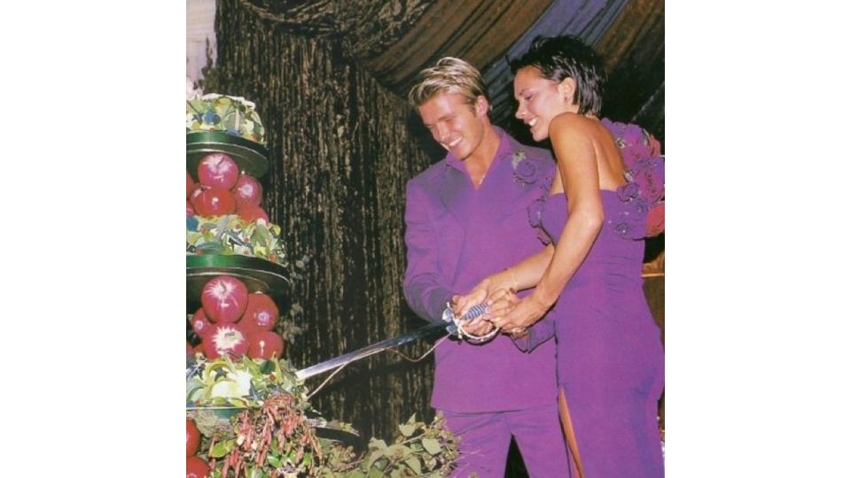 David and Victoria cutting their wedding cake with a sword