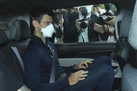 Serbian tennis player Novak Djokovic rides in car as he leaves a government detention facility before attending a court hearing at his lawyers office in Melbourne, Australia, Sunday, Jan. 16, 2022. A federal court hearing has been scheduled for Sunday, a day before the men's No. 1-ranked tennis player and nine-time Australian Open champion was due to begin his title defense at the first Grand Slam tennis tournament of the year. (James Ross/AAP via AP)