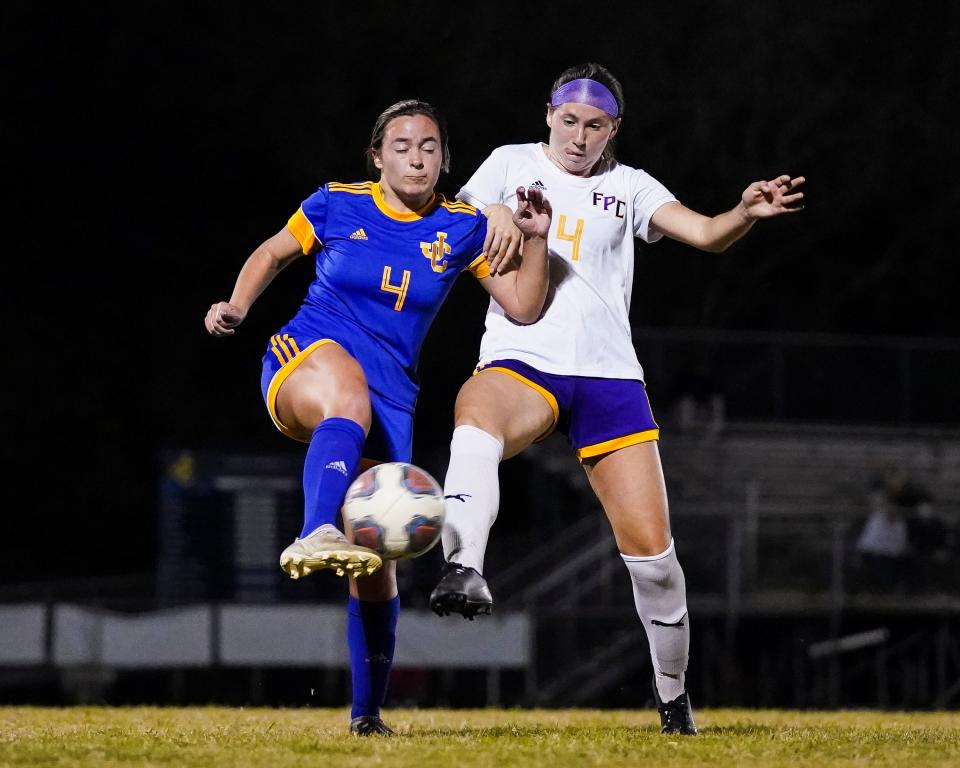 John Carroll Catholic’s Kaley Brancaccio (4) kicks the ball to a teammate as Fort Pierce Central’s Abbey Brosnihan (4) defends in a girls soccer match at John Carroll Catholic High School on Thursday, Jan. 21, 2021, in Fort Pierce.