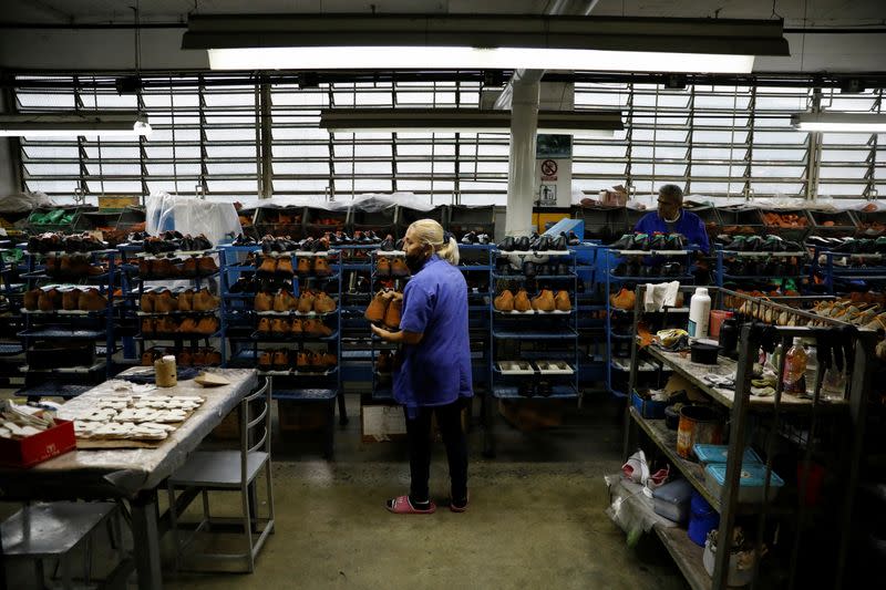 Un trabajador clasifica los zapatos terminados en el fabricante de calzado Full Time, en Caracas