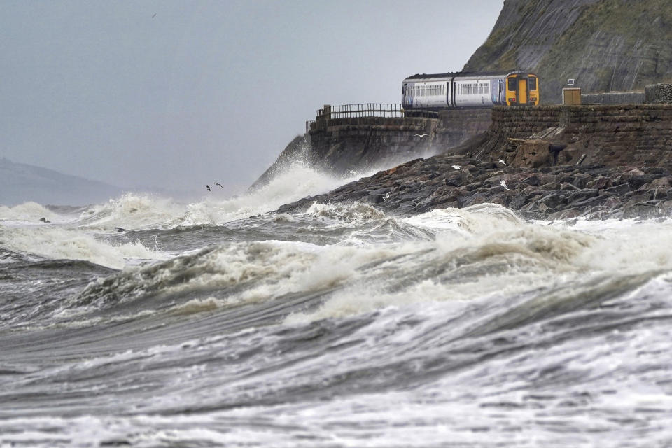 A train heads along the west coast between Whitehaven and Carlisle after Storm Dudley hit the north of the country last night, Thursday, Feb. 17, 2022. Meteorologists warned Thursday that northern Europe could be battered by a series of storms over the coming days after strong winds swept across the region overnight, toppling trees, downing power lines and causing widespread delays to rail and air traffic. (Owen Humphreys/PA via AP)