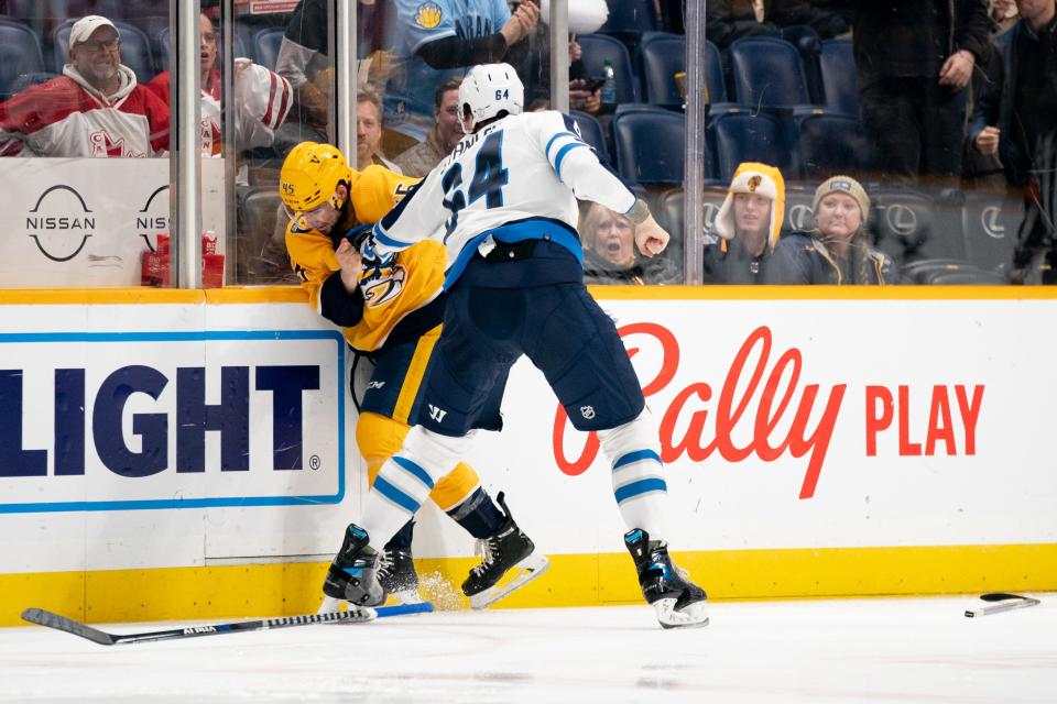 Nashville Predators defenseman Alexandre Carrier (45) fights with Winnipeg Jets defenseman Logan Stanley (64) during the first period at Bridgestone Arena in Nashville, Tenn., Tuesday, Jan. 24, 2023.