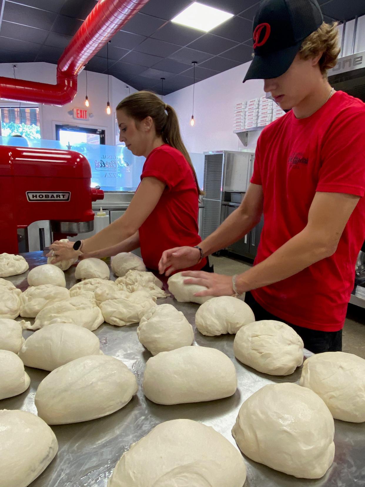 Sarah Carlson and Alan Graber prepare dough at DiCarlo’s Pizza on June 21. The grand opening is scheduled to take place July 1.