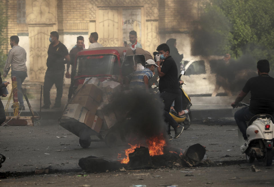 Fires set by protesters close roads during ongoing anti-government protests, near Khilani Mosque, in Baghdad, Iraq, Sunday, Nov. 3, 2019. Iraqi protesters have begun blocking roads in Baghdad to raise pressure on the government to resign. (AP Photo/Hadi Mizban)