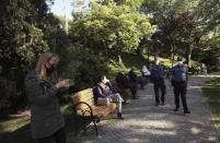 People wearing face masks for protection against the coronavirus, sit in a public garden in Ankara, Turkey, Sunday, May 24, 2020, during a four-day curfew declared by the government in an attempt to control the spread of coronavirus. Turkey's senior citizens were allowed to leave their homes for a third time as the country continues to ease some coronavirus restrictions. (AP Photo/Burhan Ozbilici)