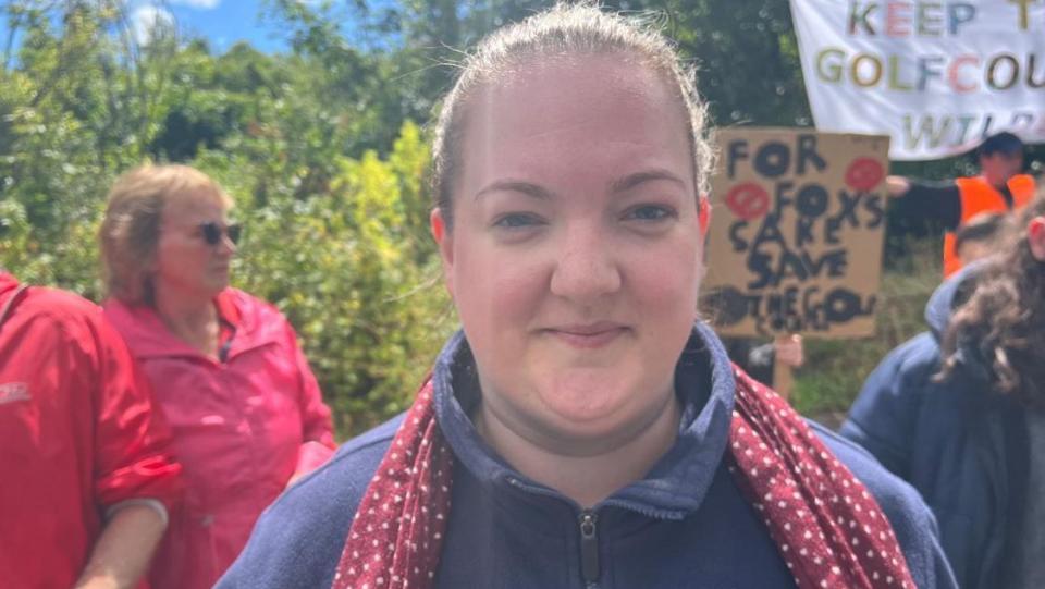 A woman in a blue fleece smiling directly at the camera