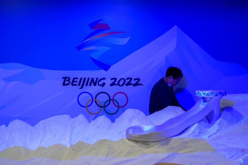 A staff member works near the emblem for Beijing 2022 Winter Olympics displayed at the Shanghai Sports Museum in Shanghai