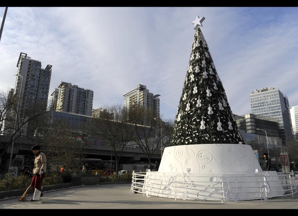 A streetsweeper works next to a giant Christmas tree outside a shopping mall in Beijing. 