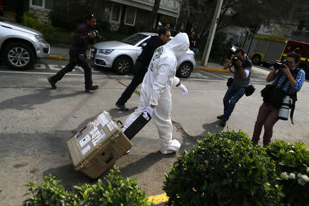 A police officer leaves the area where a bomb exploded in Santiago, September 8, 2014. REUTERS/Ivan Alvarado