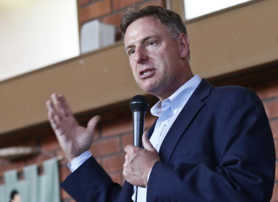 Rep. Scott Peters gestures as he speaks into a microphone.