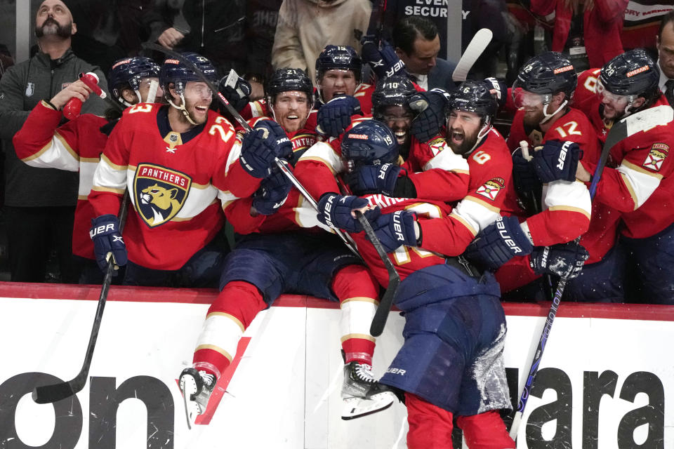 Florida Panthers left wing Matthew Tkachuk, center, celebrates with his teammates after scoring the game-winning goal against the Carolina Hurricanes during the third period of Game 4 of the NHL hockey Stanley Cup Eastern Conference finals Wednesday, May 24, 2023, in Sunrise, Fla. (AP Photo/Lynne Sladky)
