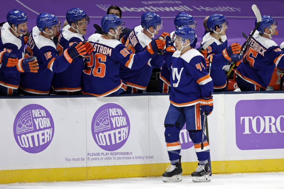 New York Islanders center Jean-Gabriel Pageau is congratulated by teammates after scoring a goal against the Boston Bruins during the third period of an NHL hockey game Saturday, Feb. 13, 2021, in Uniondale, N.Y. The Islanders won 4-2. (AP Photo/Adam Hunger)