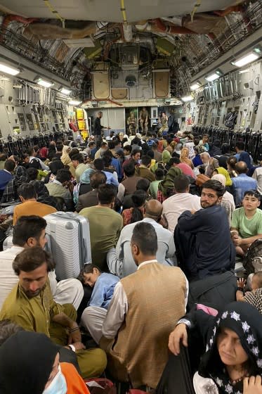 Afghan people sit inside a U S military aircraft to leave Afghanistan, at the military airport in Kabul on August 19, 2021 after Taliban's military takeover of Afghanistan. (Photo by Shakib RAHMANI / AFP) (Photo by SHAKIB RAHMANI/AFP via Getty Images)