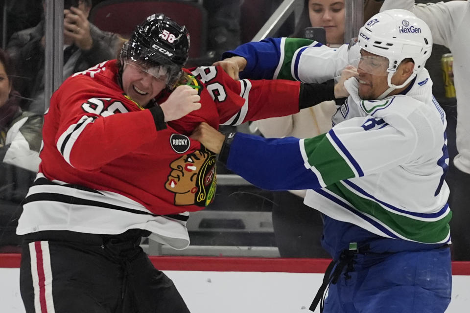 Chicago Blackhawks right wing MacKenzie Entwistle, left, and Vancouver Canucks center Dakota Joshua fight during the third period of an NHL hockey game, Tuesday, Feb. 13, 2024, in Chicago. The Canucks won 4-2. (AP Photo/Erin Hooley)