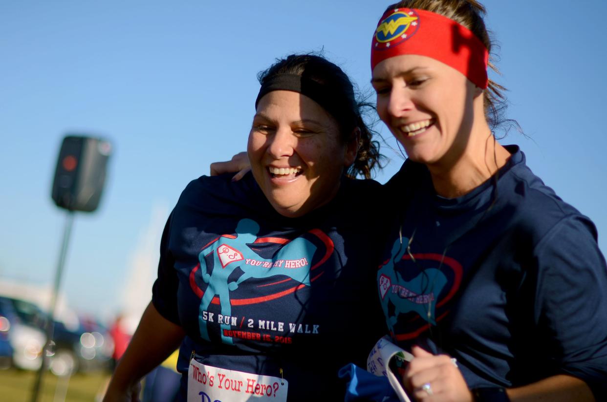 Mara McCalmon crosses the finish line during the 2015 P.S. You're My Hero 5K run at Vantage Point.