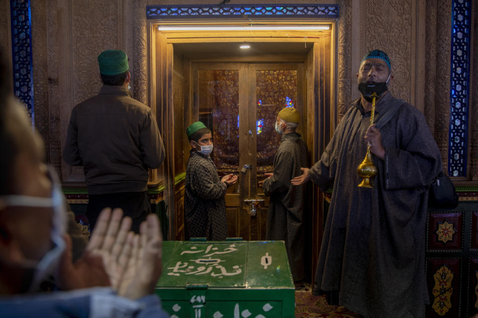 Kashmiri Muslims wearing masks as a precaution against the coronavirus pray inside the shrine of Sufi saint Shiekh Abdul Qadir Jeelani during the holy fasting month of Ramadan in Srinagar, Indian controlled Kashmir, Wednesday, April 21, 2021. (AP Photo/Dar Yasin)