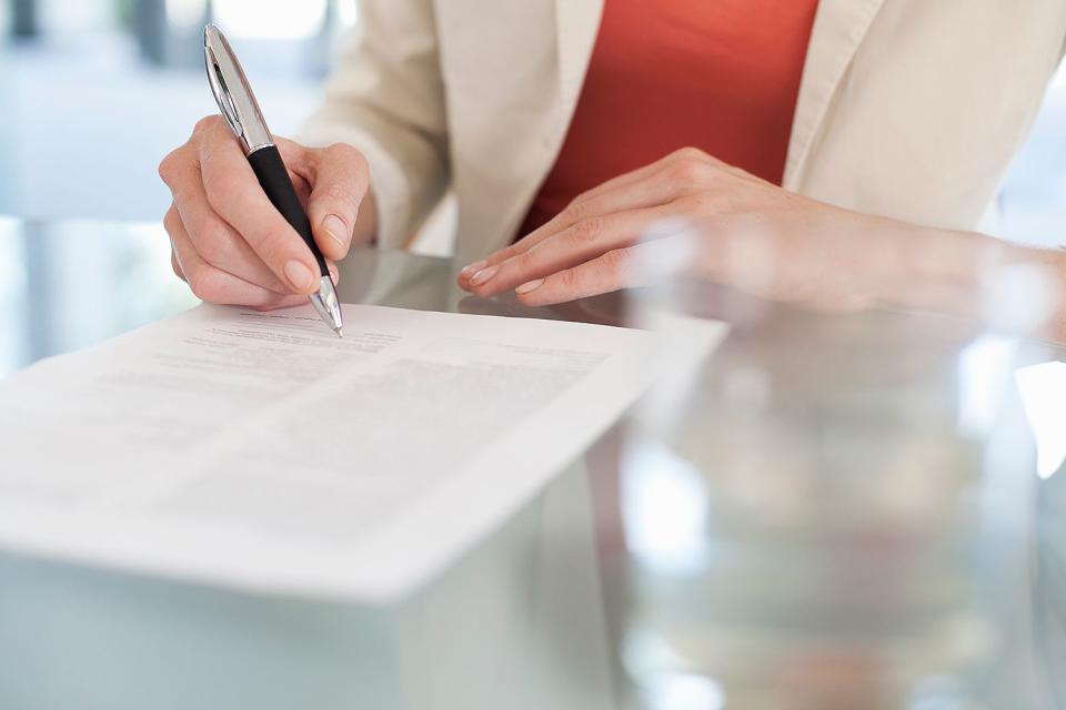 <p>Getty</p> A woman signing documents (stock image)