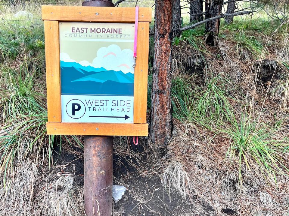 A sign points visitors toward the East Moraine community forest hiking trail.