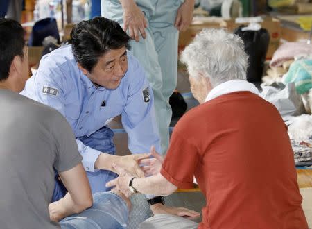 Japan's Prime Minister Shinzo Abe meets local residents staying at an evacuation center in Kurashiki, Okayama Prefecture, Japan, in this photo taken by Kyodo July 11, 2018. Mandatory credit Kyodo/via REUTERS