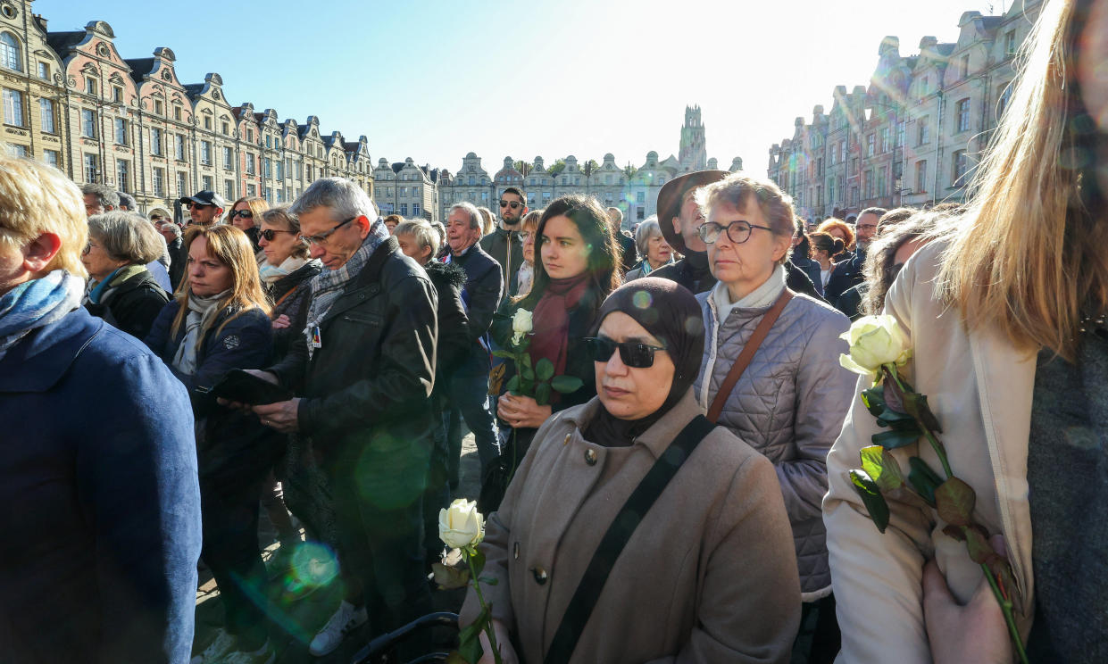Des personnes se rassemblent pour rendre hommage à la place des Héros à Arras, dans le nord-est de la France, le 15 octobre 2023, deux jours après l’assassinat de Dominique Bernard. 