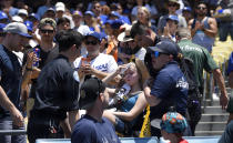 A young fan is carted away after being hit with a foul ball hit by Los Angeles Dodgers' Cody Bellinger during the first inning of a baseball game against the Colorado Rockies, Sunday, June 23, 2019, in Los Angeles. (AP Photo/Mark J. Terrill)