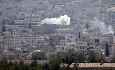 Smoke rises from the Syrian town of Kobani, as seen from near the Mursitpinar border crossing on the Turkish-Syrian border in the southeastern town of Suruc in Sanliurfa province October 8, 2014. REUTERS/Umit Bektas