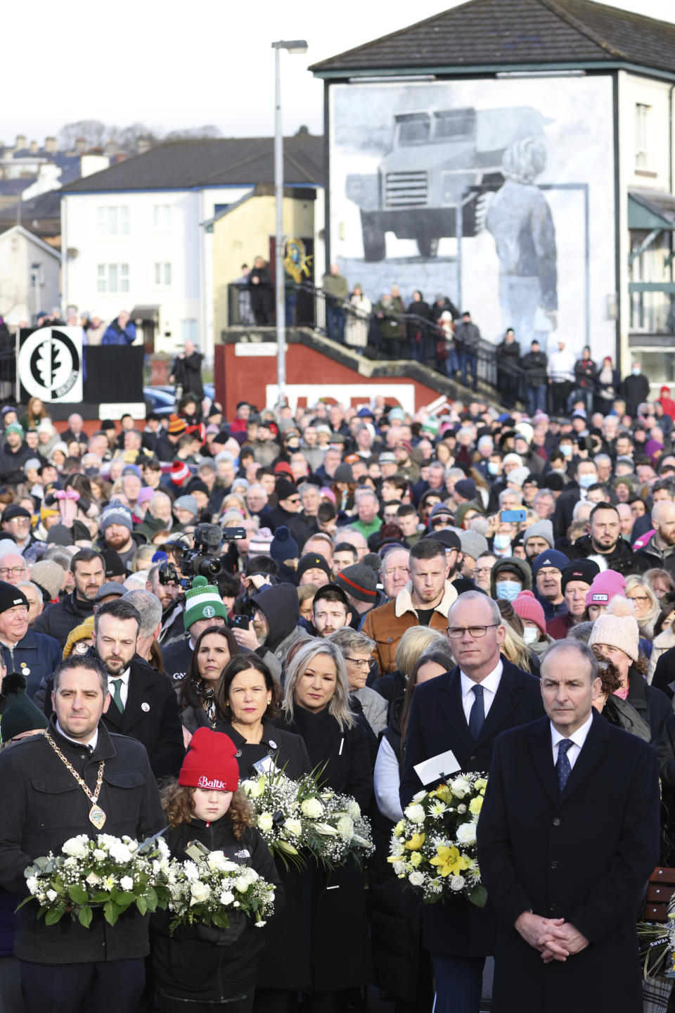 The Irish Prime Minister Micheal Martin, front right, pays his respects to the victims of Bloody Sunday during a march to commemorate the 50th anniversary of the 'Bloody Sunday' shootings in Londonderry, Sunday, Jan. 30, 2022. In 1972 British soldiers shot 28 unarmed civilians at a civil rights march, killing 13 on what is known as Bloody Sunday or the Bogside Massacre. Sunday marks the 50th anniversary of the shootings in the Bogside area of Londonderry .(AP Photo/Peter Morrison)