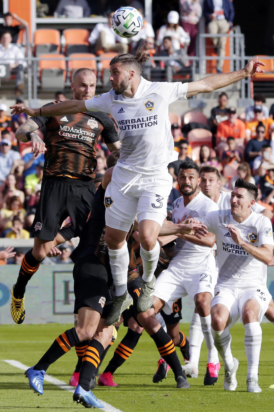 Los Angeles Galaxy defender Emiliano Insúa (3) attempts to head the ball on goal in front of Houston Dynamo defender Kiki Struna, left, during the second half of an MLS soccer match Saturday, Feb. 29, 2020, in Houston. (AP Photo/Michael Wyke)