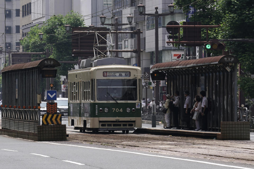 A commuter tram approaches to a stop in Hiroshima, western Japan, Monday, Aug. 3, 2020. A tram which survived the Hiroshima atomic bombing will run, without any passenger, on the streets on Aug. 6 to commemorate the day of atomic bombing in the city. (AP Photo/Eugene Hoshiko)