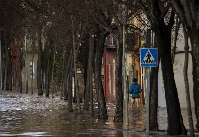 A man walks to his house during flooding following a storm in Girona, Spain