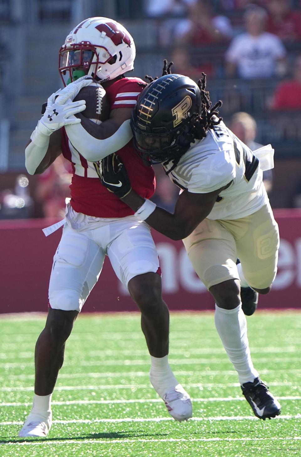 Wisconsin wide receiver Skyler Bell (11) makes a 22-yard reception before being tackled by Purdue cornerback Cory Trice (23) during the first quarter of their game at Camp Randall Stadium Saturday, October 22, 2022 in Madison, Wis.