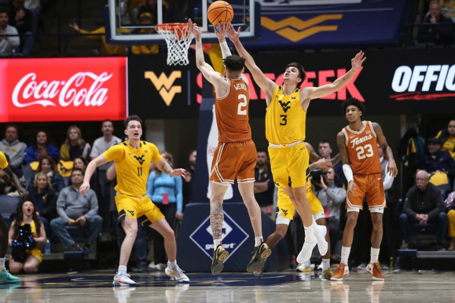 Texas guard Chendall Weaver (2) is defended by West Virginia guard Kerr Kriisa (3) during the second half of an NCAA college basketball game on Saturday, Jan. 13, 2024, in Morgantown, W.Va. (AP Photo/Kathleen Batten)