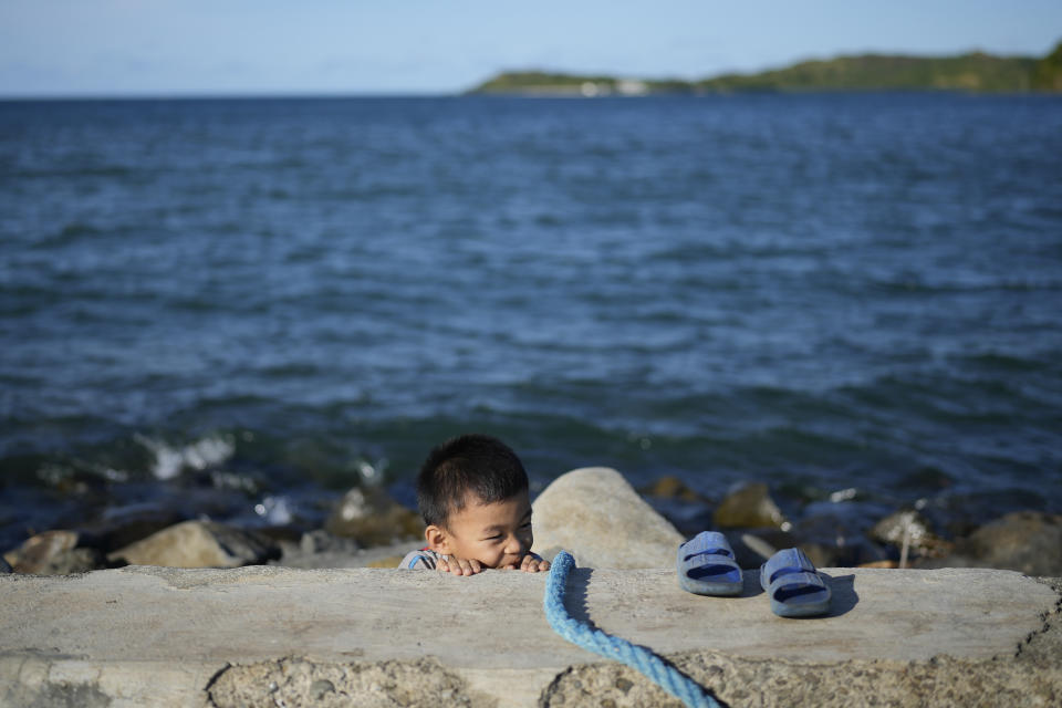 A boy plays at the port of the coastal town of Santa Ana, Cagayan province, northern Philippines on Tuesday, May 7, 2024. The United States and the Philippines, which are longtime treaty allies, have identified the far-flung coastal town of Santa Ana in the northeastern tip of the Philippine mainland as one of nine mostly rural areas where rotating batches of American forces could encamp indefinitely and store their weapons and equipment within local military bases under the Enhanced Defense Cooperation Agreement, or EDCA. (AP Photo/Aaron Favila)