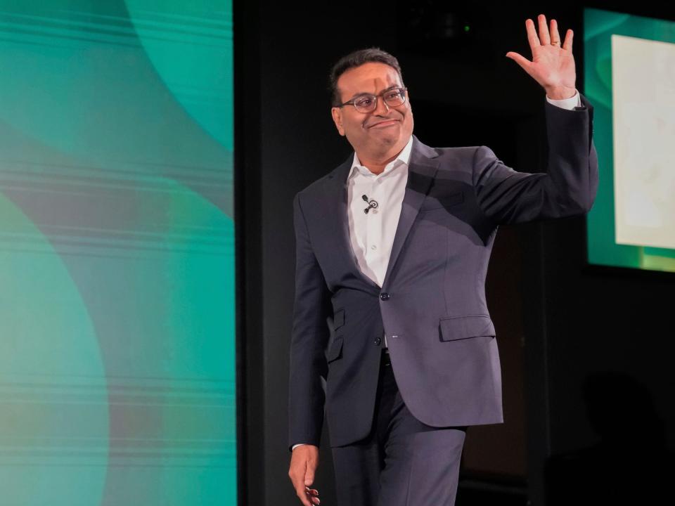 Laxman Narasimhan waves while walking onstage