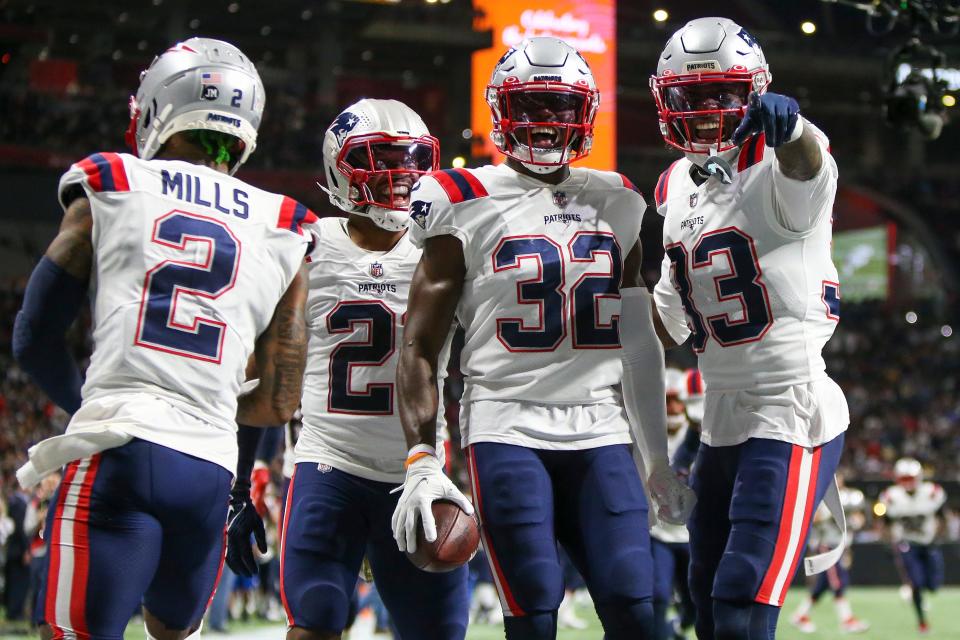 New England Patriots safety Devin McCourty (32) celebrates with teammates after pulling in an interception during a Nov.  18, 2021 game.